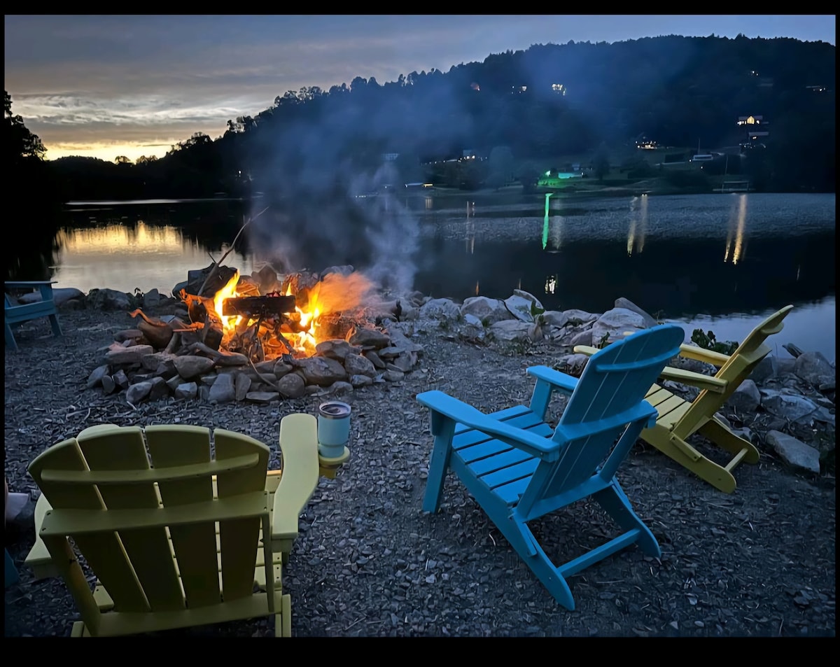 Blue-hour firepit glowing with far-shore lights