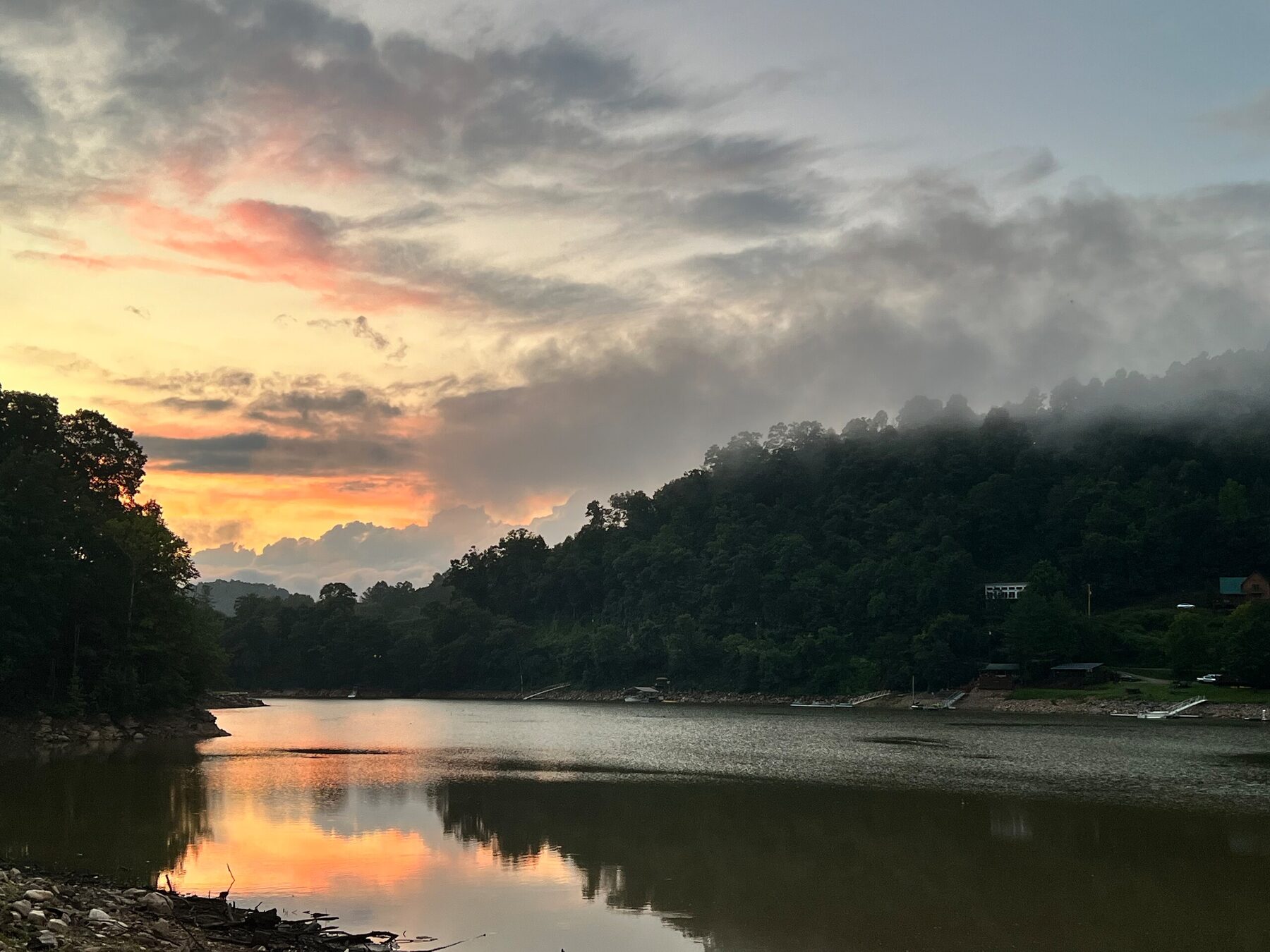 Sunset over the lake with mist rolling over the mountains